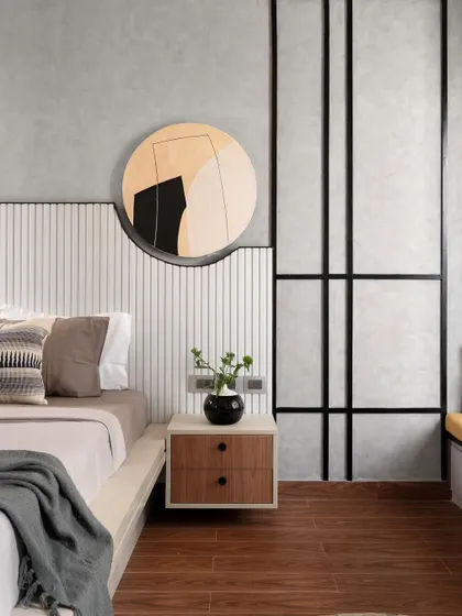The headboard is the star of this master bedroom. Crafted from white rafters, it features a cutout for a custom canvas artwork that also serves as a subtle light source. The mix of textures and black accents gives the room a sophisticated, modern look.