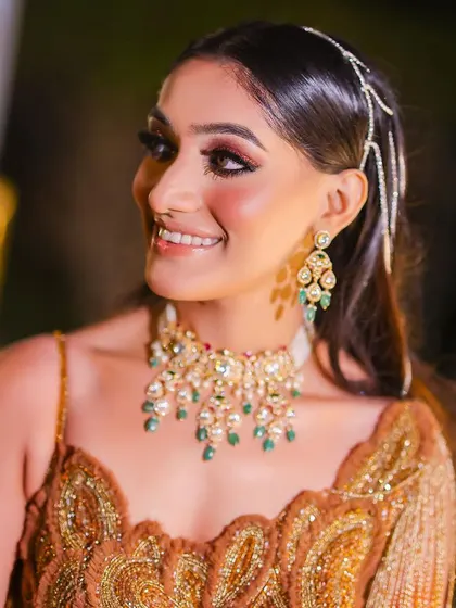 A close-up portrait of the bride, her smile radiant. This shot highlights her beautiful makeup, modern jewelry, and the happiness of her celebration.