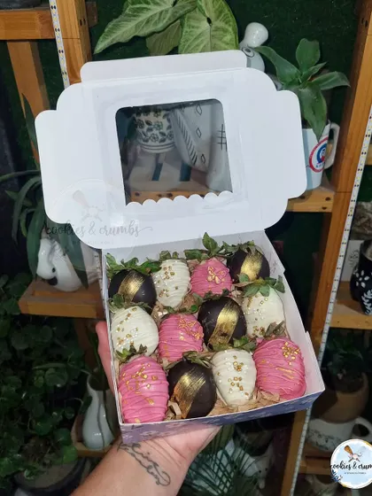 A glamorous box of chocolate-dipped strawberries. This set features dark chocolate with gold leaf and pink chocolate with gold sprinkles.