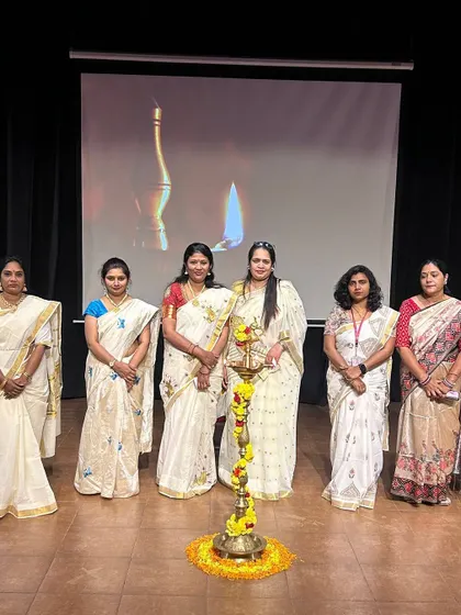 Our teachers, dressed in elegant white sarees, stand by the ceremonial lamp to inaugurate the Hindi Diwas celebration.