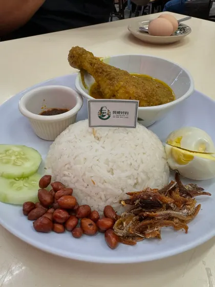 This is Nasi Lemak, what many call the national dish of Malaysia. It’s fragrant rice cooked in coconut milk, served with a spicy sambal, crispy anchovies, peanuts, cucumber, a hard boiled egg, and a delicious chicken curry. It’s a complete meal and a true taste of home.