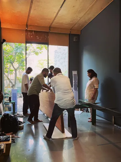 Teamwork is essential as we maneuver the heavy oak table into its final position. This process reflects our collaborative and hands-on approach to every aspect of design.