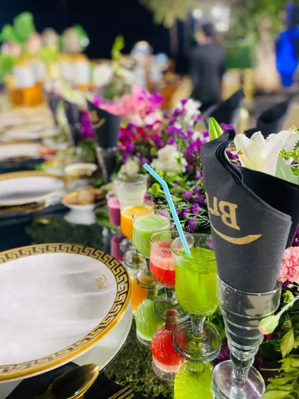 A row of colorful fresh juices served as welcome drinks on an elegantly set dining table.