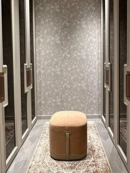 This walk-in wardrobe is a sanctuary of style and functionality, designed with a soothing neutral color palette. Exquisite mirror work embellishes the space, reflecting light and adding depth, while the layout offers practical organization with timeless elegance.