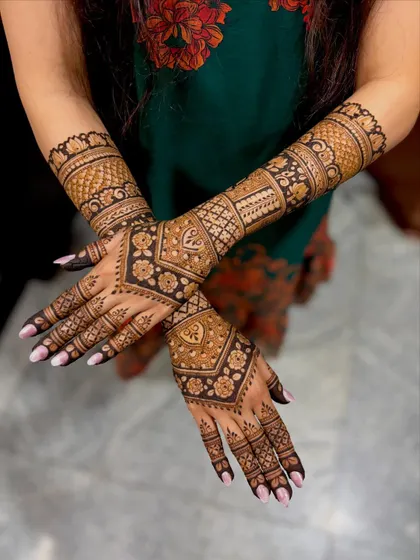 A stunning full-arm bridal design with a mix of geometric and floral patterns, creating a bold and beautiful look.