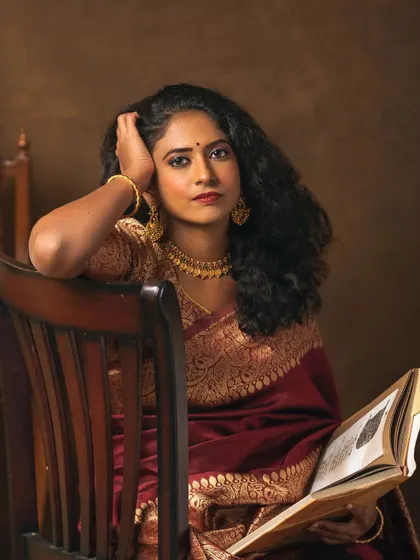 A closer view of Narayani's storybook portrait. This crop focuses on her expressive face and the antique book in her hands. Her direct gaze invites the viewer into her world, making one wonder about the story she is reading and the song on the radio.