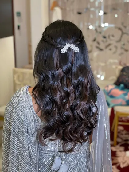 For Mishika's reception, I created this simple and elegant half-updo. A small, delicate braid is accented with a crystal clip, and the rest of the hair is styled in soft waves.