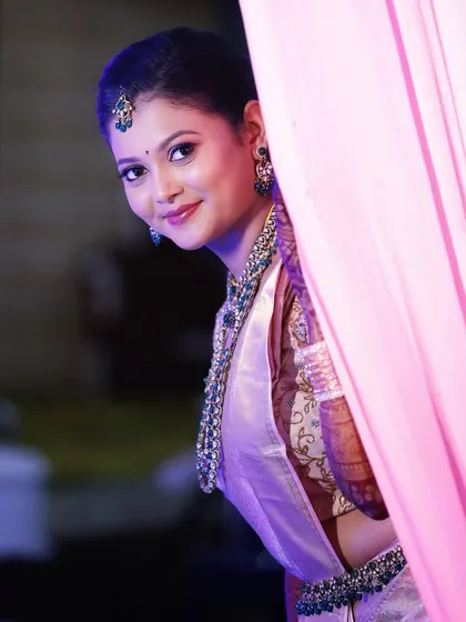 A playful peek from behind the curtain. This bride's reception makeup is soft and glowing, with a subtle smile that shows her excitement.