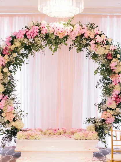 A stunning circular floral arch in pastel pink and white. This can serve as a beautiful backdrop for a Jaimala ceremony or as the mandap itself.