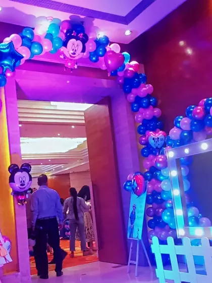 An entrance arch made of blue, pink, and chrome balloons for a Mickey and Minnie themed party. The arch frames the doorway, creating an exciting entry for kids and guests.