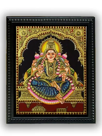 The framed version of our blue-saree Lakshmi Tanjore painting. The dark frame highlights the rich blue and gold, creating a striking and elegant piece for your wall.