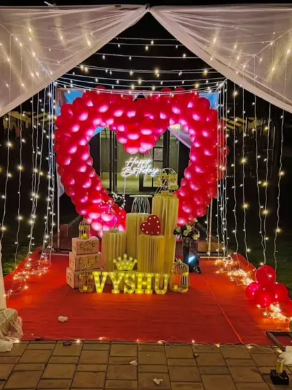 We specialize in creating unforgettable romantic surprises. This stunning outdoor cabana setup features a heart-shaped balloon arch, a red carpet entrance, and magical fairy lights, perfect for a birthday or anniversary celebration.