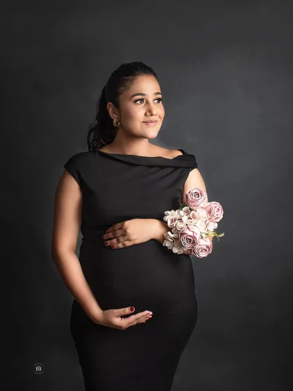 A classic and elegant solo portrait in a simple black dress against a dark backdrop, showing that casual can also be incredibly classy.