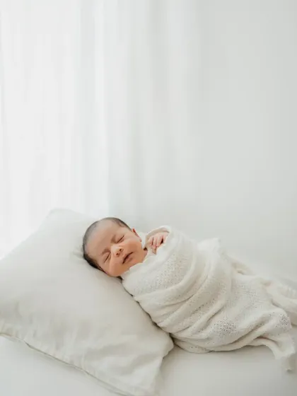 Another variation of the minimalist newborn shoot, with the baby swaddled and sleeping against a bright, airy background.