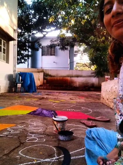 A well-deserved break and a happy selfie with the nearly-finished floor mural. Paint-splattered clothes are the uniform of a happy artist.