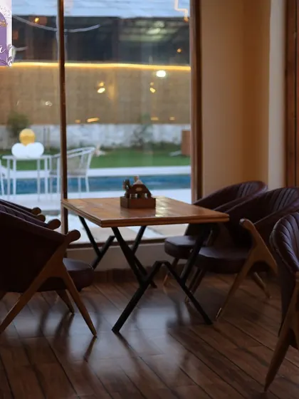 A view of the pool and lawn from our indoor seating area. Even when you're inside, you can enjoy the serene, green surroundings.