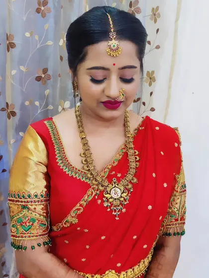A close-up of the same client, showing the detailed eye makeup and the traditional nose ring and maang tikka.