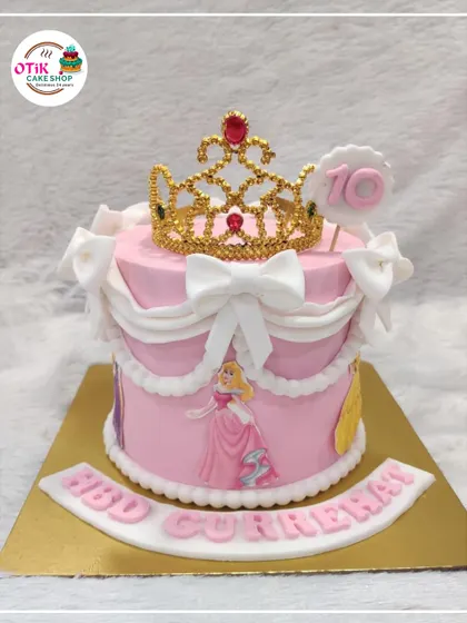 A princess dream come true, this pink cake is fit for royalty. We decorated it with elegant white swags, bows, and a sparkling golden tiara for a 10th birthday celebration.