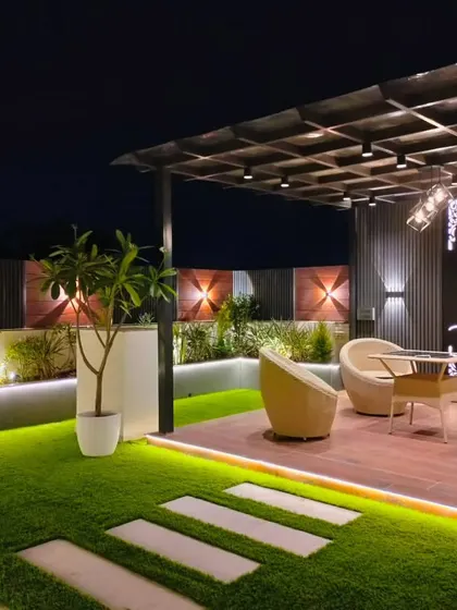 The main pergola seating area in the Sushant Lok project, featuring a backlit Buddha art piece and modern wicker furniture.