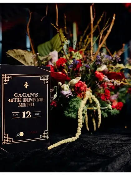 Personalization is key. I designed this custom art-deco-inspired dinner menu for a 40th birthday, which sat next to a dramatic floral arrangement, tying the tablescape into the event's moody and sophisticated theme.