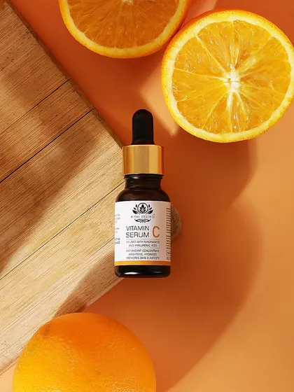 A clean and vibrant flatlay of the Vitamin C serum with fresh orange slices. This top down shot uses the key ingredient to create a visually appealing and informative image.