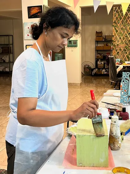 Painting a wooden box with a vibrant color. The final distressing will give it a beautiful, aged charm.