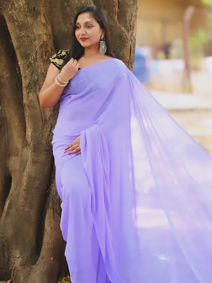 A serene portrait by a tree, with the lavender trail saree draped beautifully.