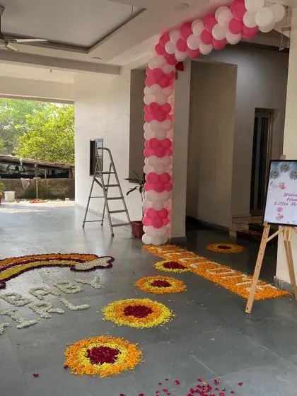 A beautiful flower rangoli design on the floor of a home for a 'Welcome Home Little Princess' event.