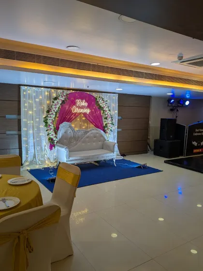 A wide view of the Roka ceremony stage setup within the venue, showing the seating, lighting, and sound system.