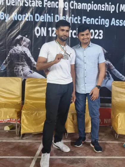 A senior medalist from the Delhi State Fencing Championship, celebrating his victory with his coach.