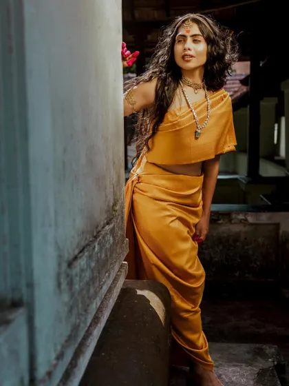 Another angle of the 'Thamara' look, showing the model interacting with the traditional architecture.