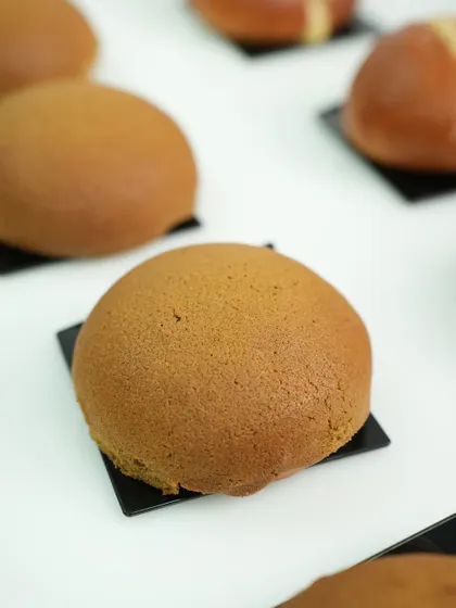A perfectly baked PappaRoti-style coffee bun, with its signature crisp topping. This is a popular item in our international breads module.
