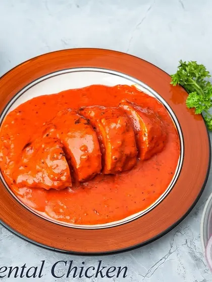 Our Oriental Chicken features tender chicken breast stuffed with our chef's special ingredients, sliced, and served in a rich, creamy, and tangy orange-colored sauce. It's a savory and comforting main course.