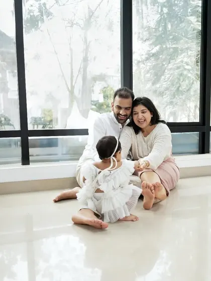 A beautiful family moment captured against a large window, using natural light to create a soft, dreamy, and divine family portrait.