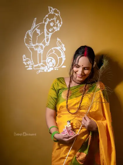 Awaiting a little Krishna with a heart full of love. This creative portrait uses a peacock feather and a small Krishna idol to add a divine touch to the maternity shoot.