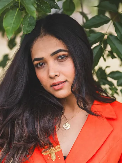 A soft and beautiful portrait of the client in her unique orange power suit.