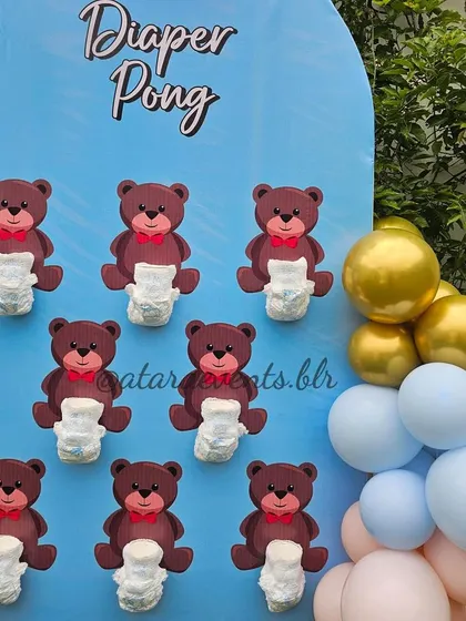 A "Diaper Pong" game setup for a teddy bear-themed baby shower. The blue and gold balloons add a festive touch to this fun and interactive guest activity.