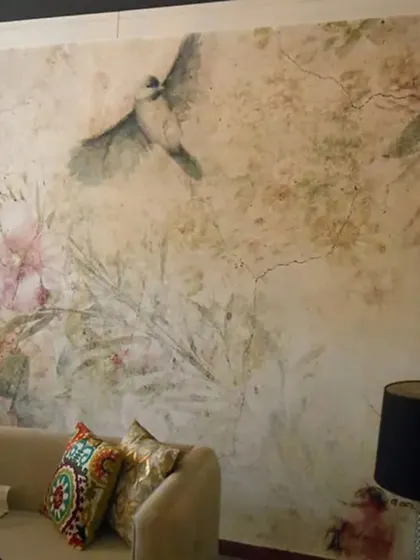 A vintage-style floral mural with birds, featuring a distressed texture that adds character and a sense of history to the design.