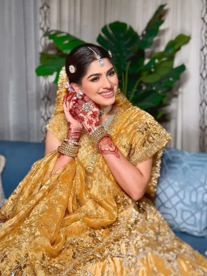 A symphony of tradition and luxury. This bride's golden lehenga is paired with diamond jewelry, showcasing a modern take on a classic color palette.