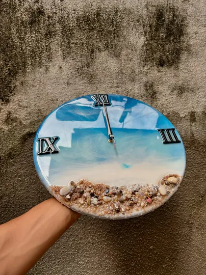 This giveaway post features the beautiful ocean-themed wall clock. The vibrant blue of the water contrasts perfectly with the natural sand, making it a stunning piece of home decor.