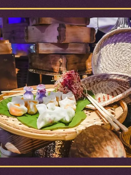 A beautiful display of our dim sum at a live station. The combination of bamboo steamers, woven baskets, and fresh banana leaves creates an authentic and rustic Asian food experience.