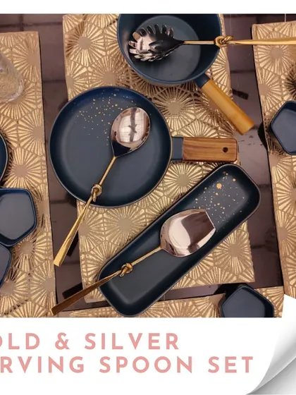 A gold and silver serving spoon set, displayed on a modern blue and gold dinner set. These spoons are designed to complement a contemporary dining aesthetic.