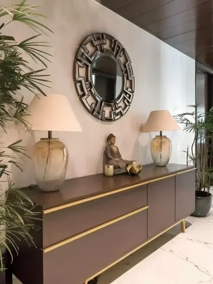 A sophisticated foyer with a dark wood console table, elegant table lamps, and a decorative mirror. The indoor plants add a touch of freshness and life to the space.