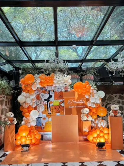 A stunning, high-fashion Hermès-inspired baby shower. The vibrant orange and white decor, set in a beautiful glasshouse, created a luxurious feel.