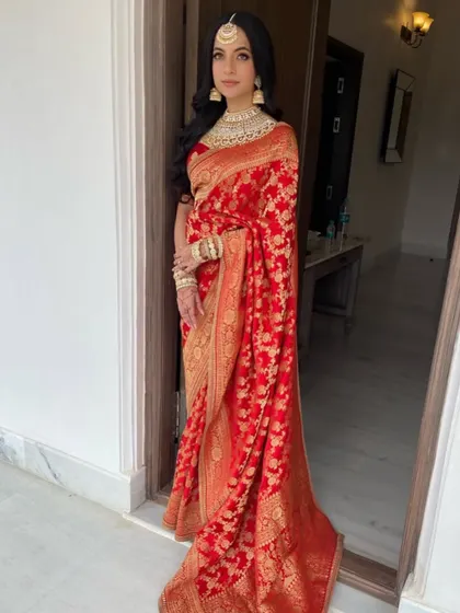 A full-length view of the bride, her classic red saree and soft waves creating a look of pure grace.