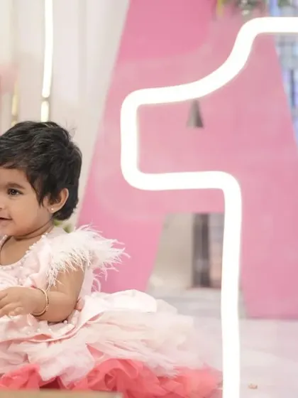 The birthday girl enjoying her special day. This photo captures the pure joy of a magical first birthday celebration.