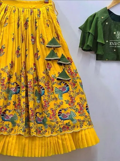 A deconstructed view of the peacock-print lehenga, which can be paired with a different style of blouse, like this green one.