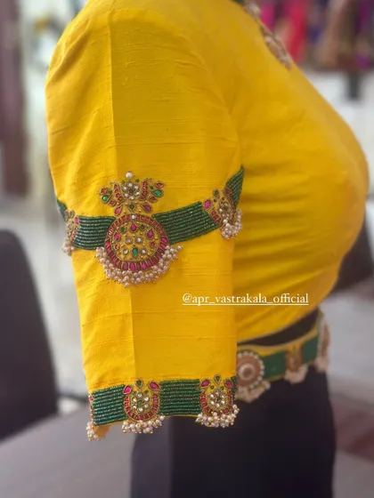 A yellow blouse with temple jewellery inspired embroidery on the sleeves. This piece also comes with a matching embroidered waist belt for a complete look.