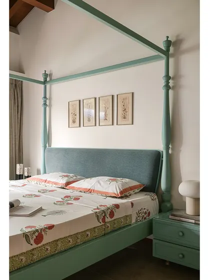 A closer look at the mint-green four-poster bed, with its sculptural posts and soft, upholstered headboard.