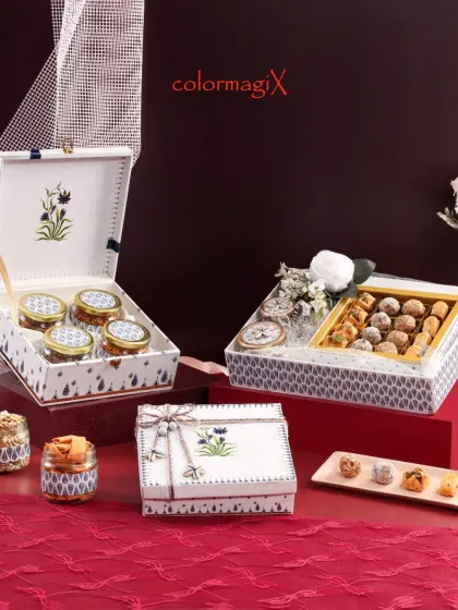 This elegant white and blue floral hamper set is a perfect blend of tradition and sophistication. The collection includes a large box for sweets and smaller matching jars for dry fruits.